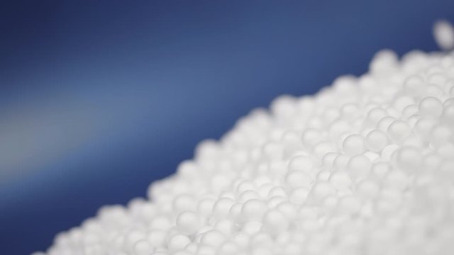 white polystyrene foam beads ball drop from Styrofoam machine for fragile stuff packaging box on blue modern luxury background for decoration