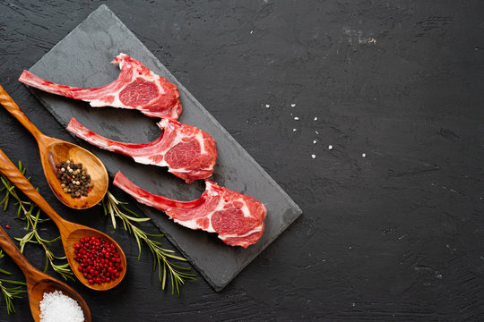Raw fresh lamb ribs on dark background, close up.