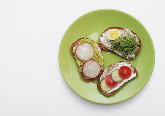  Sandwiches with healthy vegetables, tomatoes, eggs, micro greens on plate on colorful background. Healthy food concept.