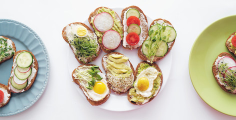  Sandwiches with healthy vegetables, tomatoes, eggs, micro greens on plate on colorful background. Healthy food concept.