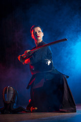 powerful caucasian female kendo warrior with shinai in hands, woman training before competitions,...