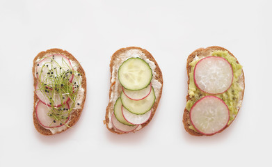 Healtht sandwiches with vegetables and micro greens on white background.