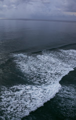 Beautiful blue sunset on the ocean with big waves and cliffs and cliffs. Bali island with its tropical and exotic nature. Sunrise over the sea and ocean. Phantom blue in sunset