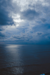 Beautiful blue sunset on the ocean with big waves and cliffs and cliffs. Bali island with its tropical and exotic nature. Sunrise over the sea and ocean. Phantom blue in sunset