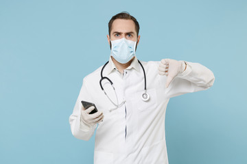 Male on-line doctor man in medical gown face mask gloves isolated on blue background. Epidemic...