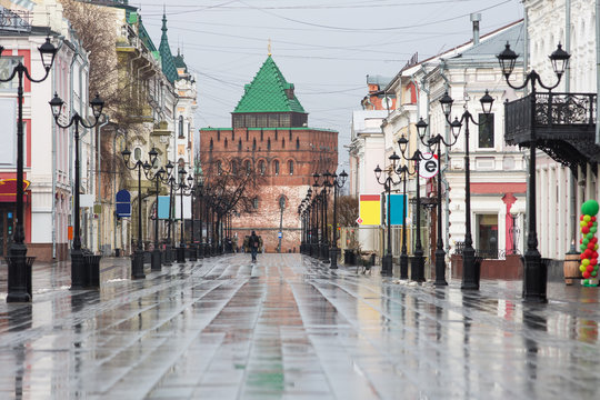 Bolshaya Pokrovskaya street in Nizhny Novgorod without people after rain with reflections of buildings on the paving stones in the rays of the spring sun