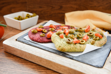 variety of different focaccia, with pumpkin, carrot and beet, on a rustic table