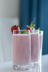 Closeup of strawberry fruit smoothies with strawberry pieces in glass