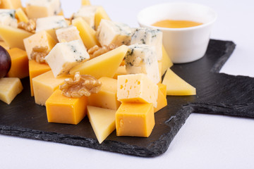 Cheese plate with red grapes, honey and walnuts
