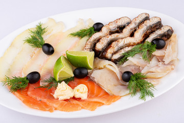 Fish plate with red fish, canned food and halibut, served with lime and dill and olives