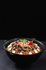 Magic photo of tasty pilaf. National Uzbek dish like fried rice with sliced meat. Food in cauldron. Best quality content