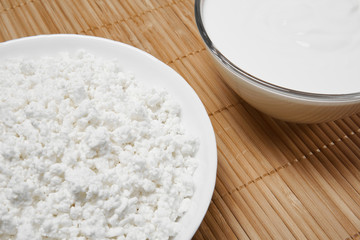 still life background with fragments of bowls with cottage cheese and sour cream on the table