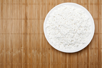 bowl with cottage cheese on the table, top view