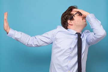 Caucasian tired man in tie and blue shirt refusing to talk