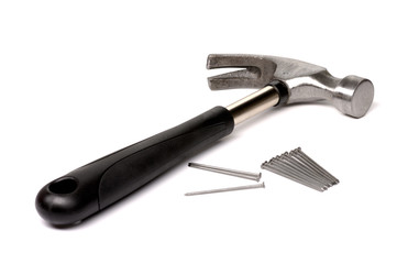 A hammer with a black handle and nails lies diagonally on a white isolated background.