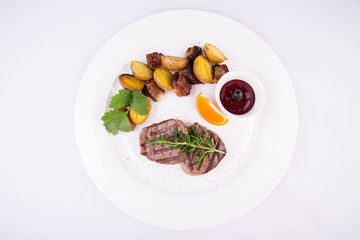 Grilled steak meat, served with potatoes in mundiers and blackcurrant sauce
