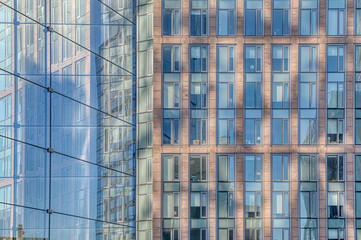 Obraz premium Architectural detail of the facade with multiple reflections of other buildings and the sun in New York