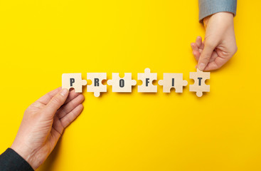 Hands of businessmen are holding a puzzle with the word 
