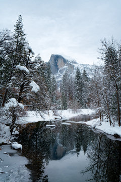 View of river flowing through forest with Half Dome in background