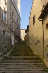 ancient stone staircase through buildings in Perugia, Italy