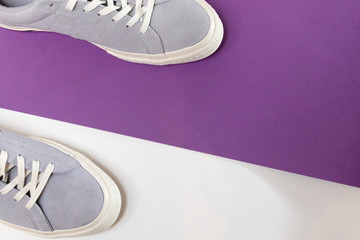 White and grey men's sneakers on a white and purple background. Flat spoon, top view minimal background. The concept of a Fashion blog or magazine.