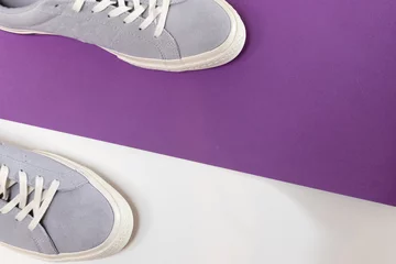 Tuinposter White and grey men's sneakers on a white and purple background. Flat spoon, top view minimal background. The concept of a Fashion blog or magazine. © vitalii_demin