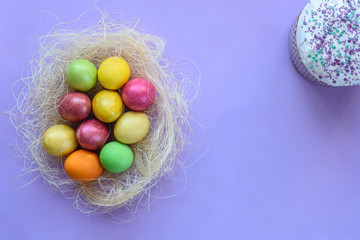 Easter eggs on a purple background, next to Easter cake