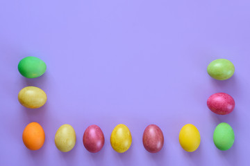 Easter eggs laid out around the perimeter on a purple background