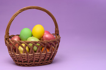 Basket with easter eggs on a dark pink background