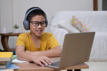 Young collage student using computer and mobile device studying online.