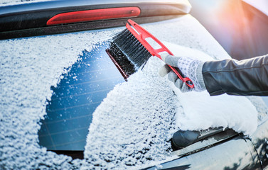 Clean car window from snow in winter time. Windshield cars cleaning.