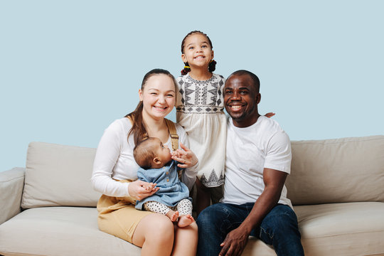 Cheerful happy family posing for a family photo in a studio