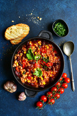 Chili con carne - traditional mexican minced meat and vegetables stew in tomato sauce. Top view with copy space.