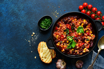 Chili con carne - traditional mexican minced meat and vegetables stew in tomato sauce. Top view with copy space. - obrazy, fototapety, plakaty