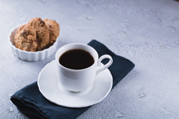 White cup of coffee with oatmeal cookies and coffee maker, breakfast concept, selective focus