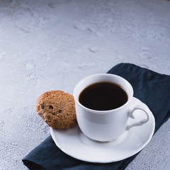 White cup of coffee with oatmeal cookies and coffee maker, breakfast concept, selective focus