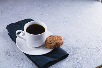 White cup of coffee with oatmeal cookies and coffee maker, breakfast concept, selective focus