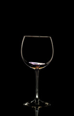 Naklejka na ściany i meble Glass of wine in black background