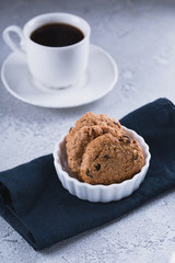 White cup of coffee with oatmeal cookies and coffee maker, breakfast concept, selective focus
