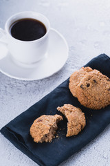 White cup of coffee with oatmeal cookies and coffee maker, breakfast concept, selective focus