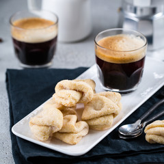 Two cups of fresh espresso on white rectangular tray with milk jar and coffee maker, copy space, breakfast concept 