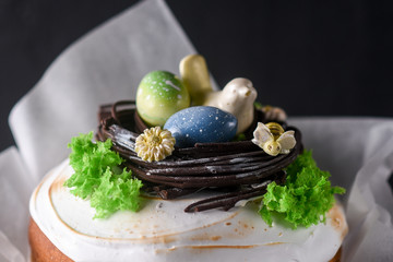 Easter, Easter cake on a dark background, decorated chocolate nest with eggs and a bird of chocolate, beautiful scenery, soft focus