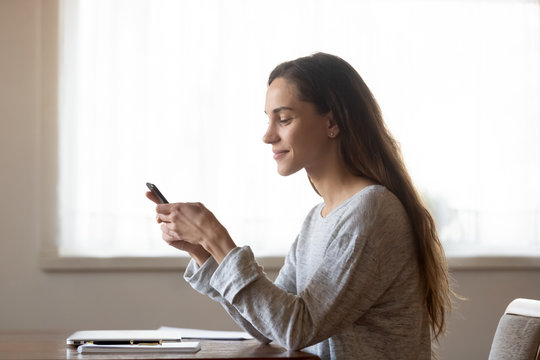 Side View Pleasant Millennial Mixed Race Woman Holding Smartphone