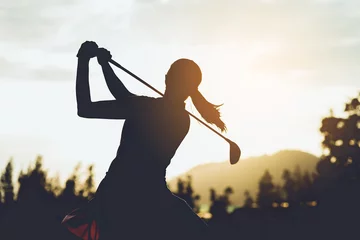 Wandcirkels aluminium Silhouette of  young professional female golf player hit sweeping and keep golf course doing golf swing,she does exercise for relax time © miraclebuggy