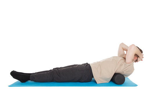 Handsome man shows exercises using a foam roller