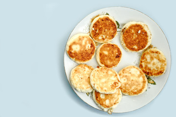 curd pancake on a white plate. blue table background.