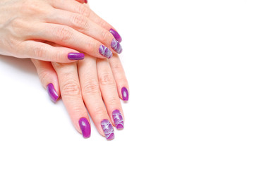 female fingers with painted nails. lilac nails with a pattern.