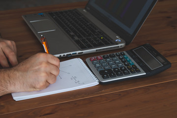 young man calculating economic situation working with leptop and calculator