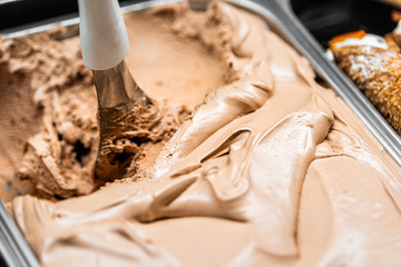 Macro closeup of chocolate coffee gelato ice cream with swirl scoop on display in cafe store shop in famous Florence Italy Firenze Centrale Mercato