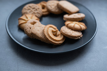 Homemade butter cookies on a grey plate on concrete background. Danish cookies. Close up view.